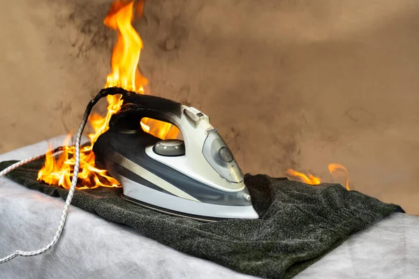 Forgotten included electric iron for ironing clothes. Careless handling of household appliances can cause a fire. Household fire started in the house.