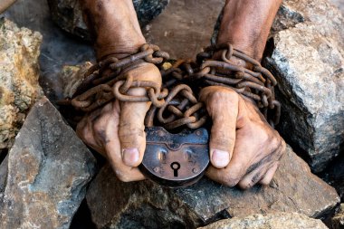 İnsanların elleri zincirlidir. Büyük eski demir kale. Büyük gri taşlar. Paslı bir zincire sarılmış bir kölenin ince, kirli elleri..