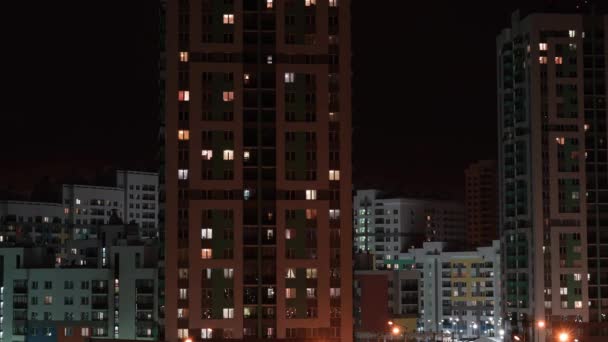야간 주거 지역. 밤에 창문의 전등을 켰다 껐다 하는 주거용 주택들 이 시간의 경과를 보였습니다. 창문을 통해 본 모습 — 비디오