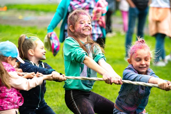 Regionen Tjeljabinsk, Ryssland - juli 2019. Barn av olika nationaliteter är vänner på färgfestivalen. Dra i krig. Barn brinner för spelet. Livliga känslor i barnens ansikte — Stockfoto