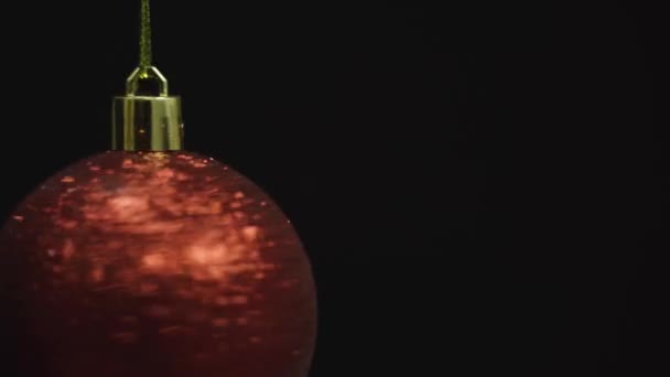 Boule rouge tourne sur fond noir, Noël et Nouvel An décoration isolée sur sombre, boucle sans couture 