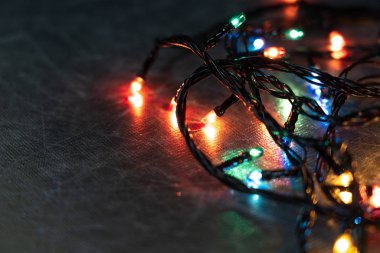 Masada karanlıkta renkli ampuller parlıyor. Uzayı kopyala Masada parlayan Noel ışıkları, yakın plan