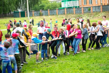 Chelyabinsk Bölgesi, Rusya - Temmuz 2019. Farklı milletlerden çocuklar renk festivalinde arkadaşlar. Halat çekme. Çocuklar oyuna tutkuyla bağlıdır. Çocukların yüzünde canlı duygular
