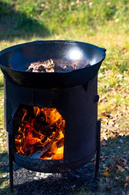 Büyük bir kazanda ateşte et parçaları pişir. Büyük bir kazanda kaynamış et. Vejetaryen olmanın dehşeti. Sokakta büyük et parçaları pişiyor.