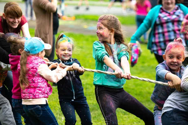 Regionen Tjeljabinsk, Ryssland - juli 2019. Barn av olika nationaliteter är vänner på färgfestivalen. Dra i krig. Barn brinner för spelet. Livliga känslor i barnens ansikte — Stockfoto