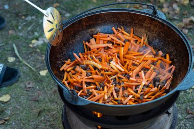Pilav yağında dilimlenmiş havuç. Soğan ve havuç ayçiçeği yağında tavada kızartılır.