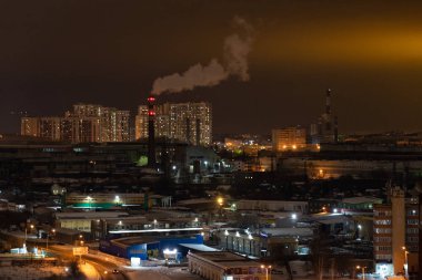 Kış gecelerinde yerleşim yerleri. Çok katlı binaların parlayan pencereleri. Bahçede bir sürü park edilmiş araba var.