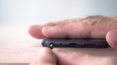 Süzgeç akıllı telefonun fişini tak ve çıkar. Kulaklıkları akıllı telefona bağlıyorum. Kulaklığın aşırı yakın çekim mini jant prizi
