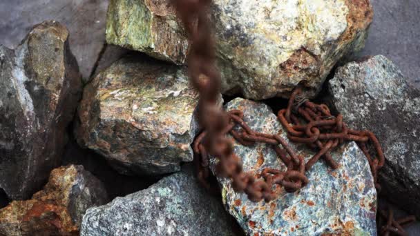 石の上に古い錆びた鎖を引っ張れ奴隷労働だ錆びた古い鎖が地面に横たわっている — ストック動画