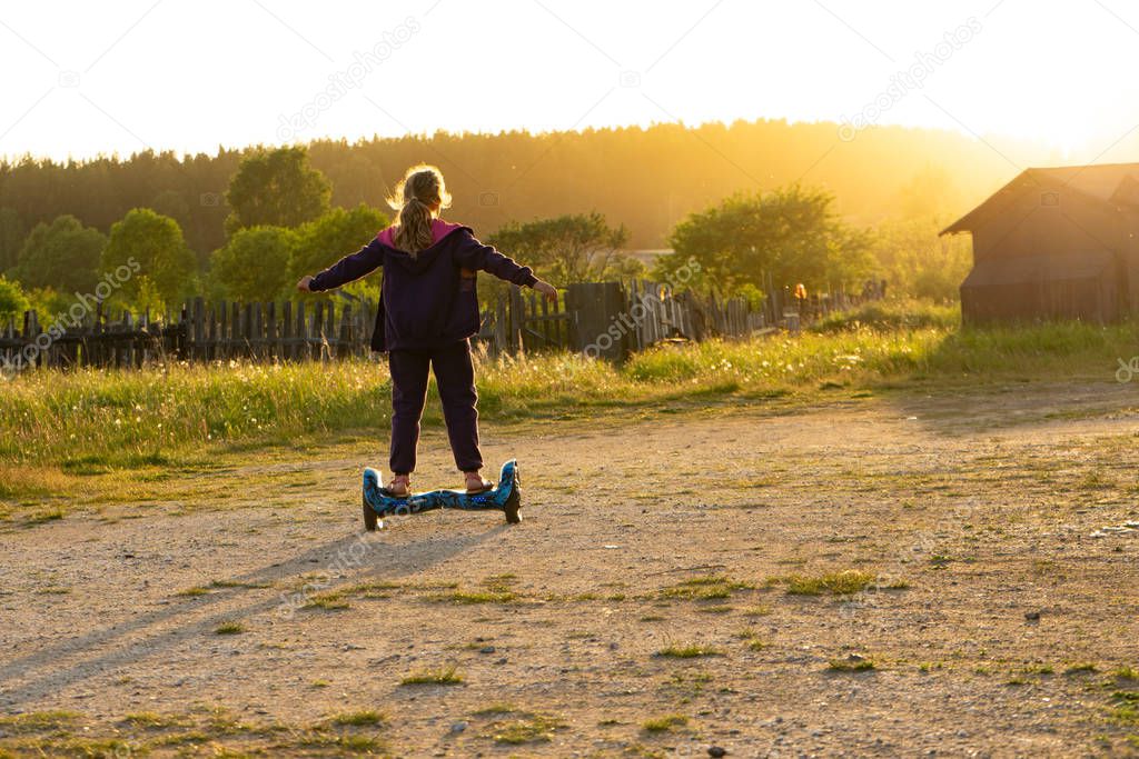 Girl riding a scooter on a warm summer evening