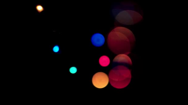 Luzes multicoloridas de diferentes tamanhos mudam em um fundo preto — Vídeo de Stock