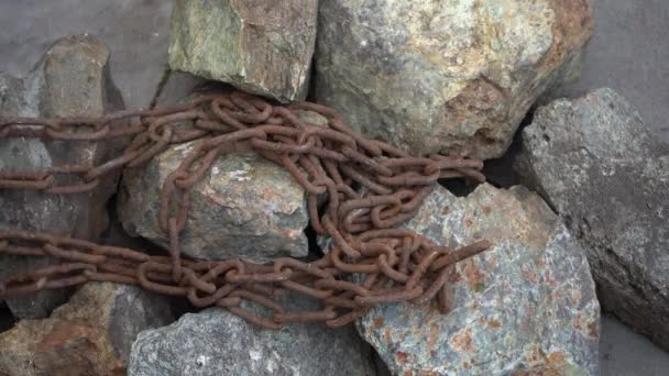 Tirare la vecchia catena arrugginita sulle pietre verso di te. Lavoro schiavo. Una vecchia catena arrugginita giace a terra — Video Stock