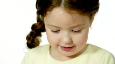 Cute girl 5-6 years old looking at the camera and smiling. Closeup portrait on a white background.