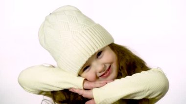 Cute girl 5-6 years old looking at the camera and smiling. Closeup portrait on a white background