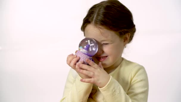 Дитина Вивчає Чарівну Снігову Кулю Дівчинка Років Виглядає Лялька Студії — стокове відео