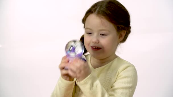 Child Examines Magic Snow Globe Girl Years Old Looking Doll — Stockvideo