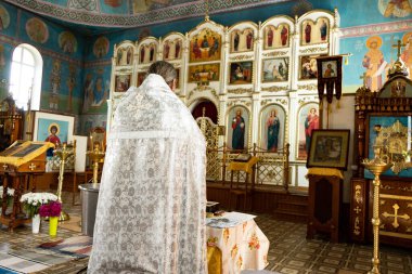 Yekaterinburg, Rusya - Temmuz 2019. Kilisede bebek vaftiz töreni. Küçük ahşap bir Hıristiyan kilisesinde yeni doğmuş bir bebeğin kutsal Ortodoks ayini