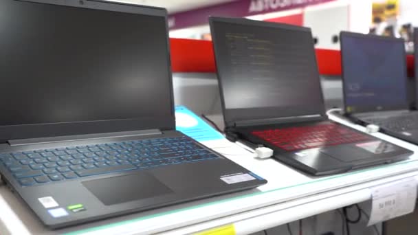 Yekaterinburg,ロシア- 2020年2月。電子店の棚の上のノートパソコン。異なるラップトップを持つコンピュータストア内のラック. — ストック動画