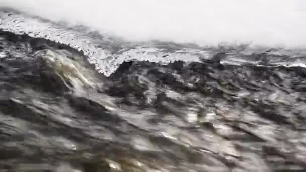Hızlı hareket eden su, eriyen buzun yanından geçiyor. Yakın plan.. — Stok video