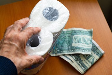 Tuvalet kağıdı rulosundaki dolar. Tuvalet kağıdı ve para.