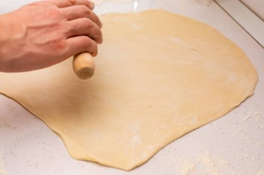 Mangırı çıkar. Fırıncı hamuru ahşap mutfak masasına serpiştirir..