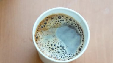 Kağıt bardakta köpüklü kahve içeceğim. Tek kullanımlık karton bardak, fotokopi alanı olan üst görüntü. Tek kullanımlık eko kağıt tablo takımı