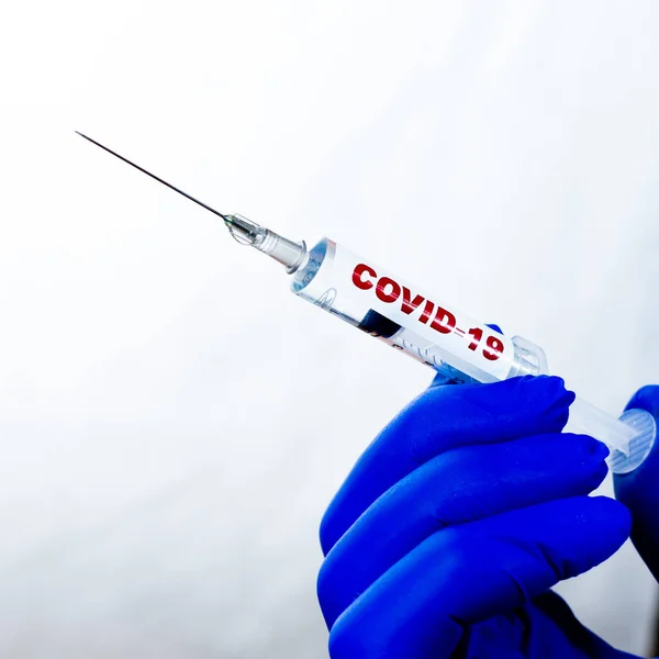 Coronovirus vaccine in syringe. The new vaccine is ready.Close-up of the liquid drop at the end of the needle. Vaccination against coronovirus.