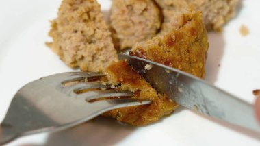 Et pirzolası yakın plan. Çatal ve bıçak. Kıymalı et. Yağlı kıyma. Beyaz tabak, çatal ve bıçakla tek kızarmış pirzola..