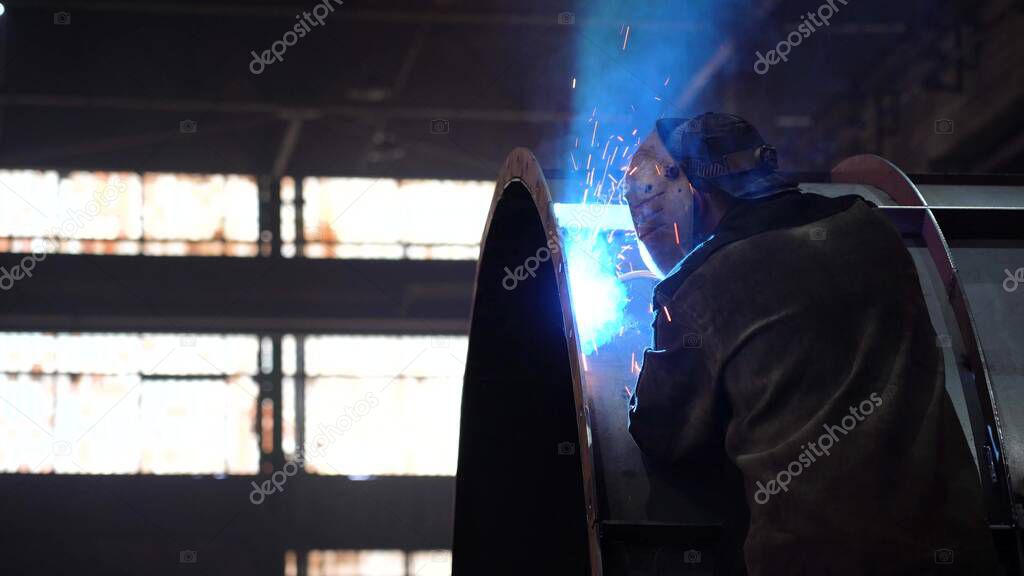 The work of the welder. Welding work in the factory floor.