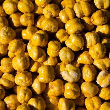 Kızarmış gram chana veya nohut fıstığı. Parlak güneş ışığı keskin gölgeler verir.