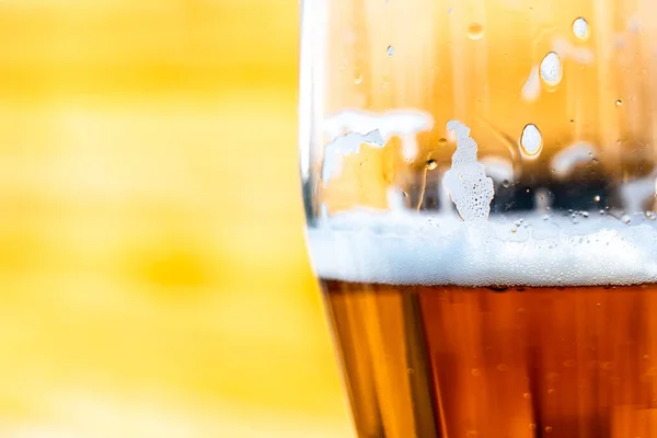 Light beer in a glass wine glass on a picnic on the nature. Beer foam on the walls of a glass In the sunlight