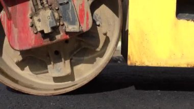 Çalışan bir buz pateni pistine yakın çekim. Sıcak asfalt. Askı tamiri. Tekerleğin büyük çalışma makinesi yeni asfalt yapar.