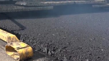 Yeni bir sıcak asfalt tabakası. Asfalt kaldırım taşı otoyolda asfalt uyguluyor. Sokakta asfalt uygulamak için kullanılan bir ekipman.