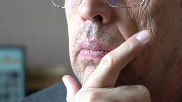 Mature man scratches his unshaven chin in thought over a difficult problem — Stock Photo, Image