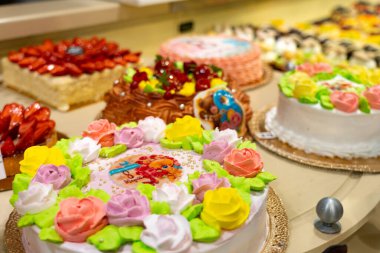 Dükkan vitrininde kek ve hamur işleri. Çeşitli donutları olan bir pastane, Creme brulee, meyveli ve meyveli kekler..