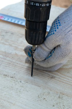 Tahta tahtaya elektrikli tornavidayla vidalayın, yakın plan..