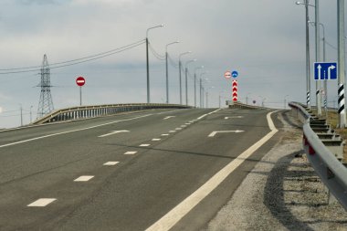 Yarı boş otoyol karantinaya alındı. Virüs salgını yüzünden trafiği azalttım. Düz, boş yeşil bir arazide ufka giden trafiği olmayan boş bir otoyol..