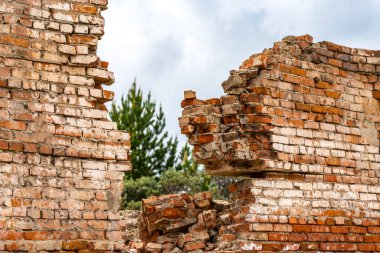 Duvardaki yarık. Yakın plan. Harap olmuş kırmızı tuğla duvar. Gökyüzüne karşı duvarın enkazı. Evlerin yıkıntıları.