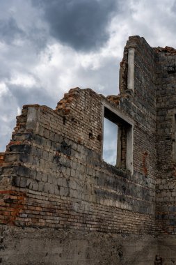 Duvardaki yarık. Yakın plan. Harap olmuş kırmızı tuğla duvar. Gökyüzüne karşı duvarın enkazı. Evlerin yıkıntıları.