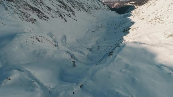 Drone aérien tiré sur la célèbre route de montagne serpentine Transfagarasan recouverte de neige en hiver — Video