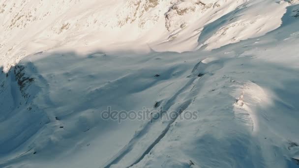 Drone aéreo disparó sobre el famoso camino serpentino de montaña Transfagarasan cubierto de nieve en invierno — Vídeos de Stock