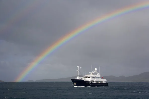 Luxury yacht under a rainbow in the South Pacific — Stock Photo, Image