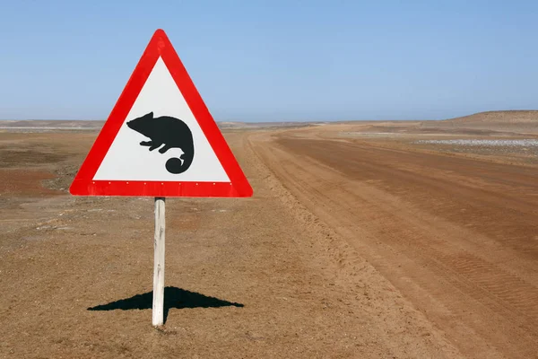 Señal de advertencia 'Camaleones' en una remota carretera desértica en Namibi —  Fotos de Stock