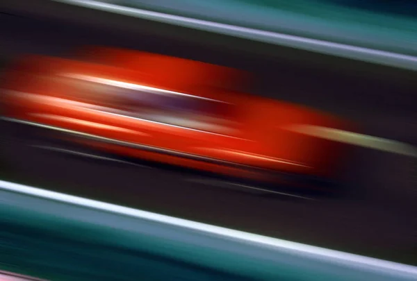 Ταχύτητα - θόλωση του ένα γρήγορο κινούμενο κόκκινο αυτοκίνητο — Φωτογραφία Αρχείου