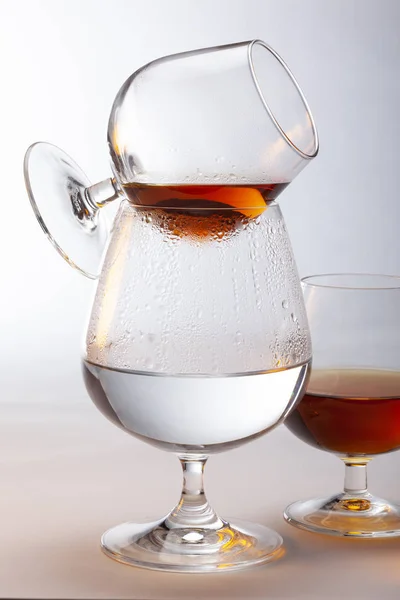 A snifter of brandy being warmed above a glass of hot water — Stock Photo, Image