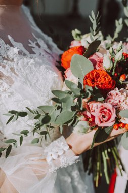 Düğünde, gelin ve damat birlikte güzel giysiler içinde düğün buketini ellerinde tutuyorlar.