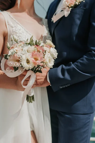 Wedding. The bride and groom with a wedding bouquet, holding on hands and standing on wedding ceremony of the outdoor in the nature backyard. — Stock Photo, Image