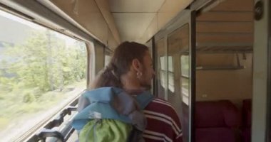 Ayrı kompartımanları olan bir trende koltuk arayan bir adam.