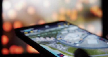 Tablet aygıtında spor araba yarışı oynayan adam F1 Yöneticisi