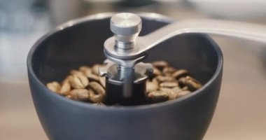 Taze aromatik espresso için kahve çekirdeklerini elle öğütüyorum.